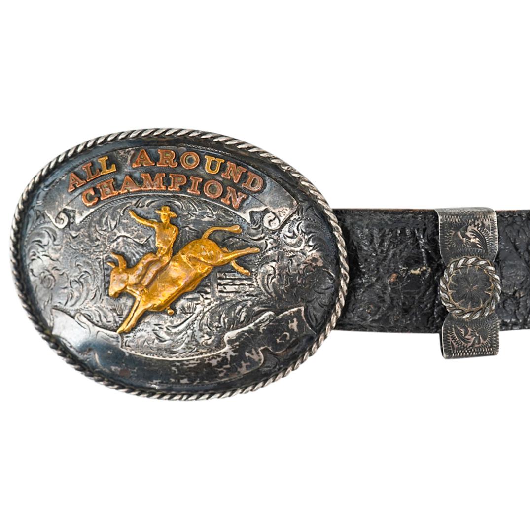 Diablo Mfg. Co. Sterling Silver And 10K Gold Buckle W/ Leather Belt: DESCRIPTION: Genuine leather belt featuring a sterling silver buckle by Diablo Manufacturing Co. emblazoned in 10K gold overlay lettering "ALL AROUND CHAMPION" over a gilt bull rider surrounded by etc