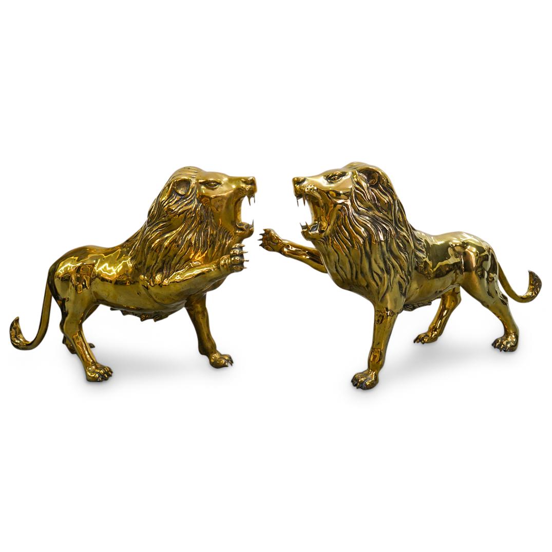 Pair Of Gilt Brass Lions: DESCRIPTION: Two matching gilt brass lions, each fashioned with a roaring face and a raised right fore paw. CIRCA: 20th Century ORIGIN: Continental DIMENSIONS: H: 22.75-23.5" W: 11.25-11.5" L: 37" Hav