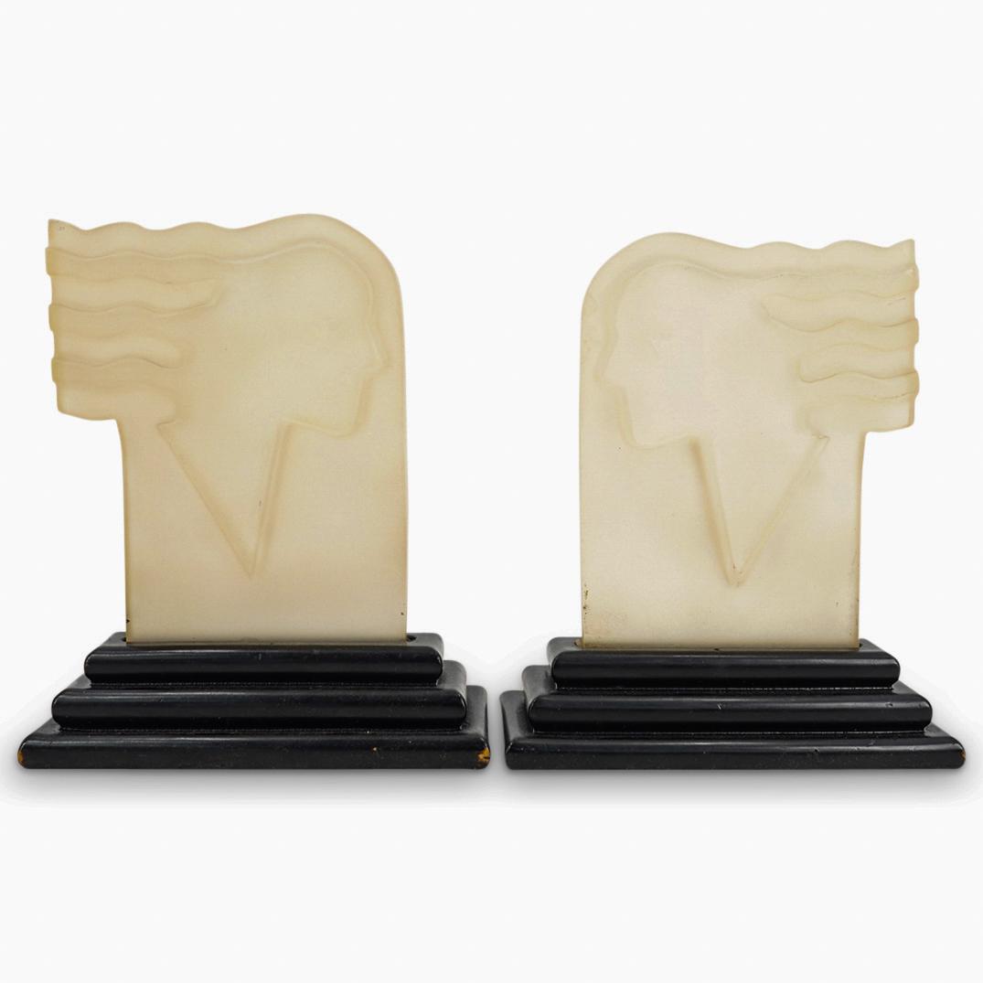 Hagenauer Style Frosted Lucite Face Plaques: DESCRIPTION: Hagenauer style frosted lucite face plaques on wood beveled stands. CIRCA: 20th Century ORIGIN: Continental DIMENSIONS: H: 11.5" x W: 3.75" x L: 9.5" Have a similar item to sell? Contact: