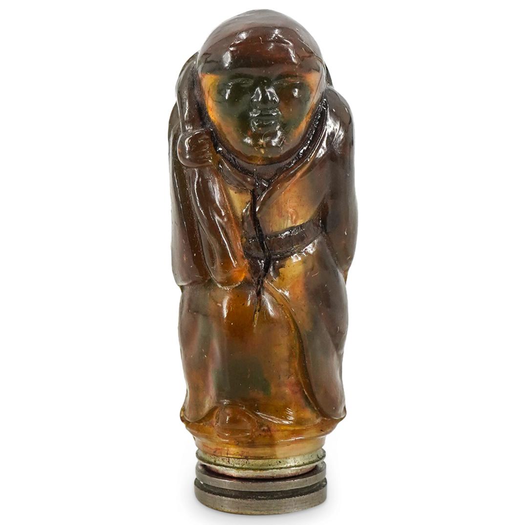 1920 Hemsey 'Le Rouge Dieze' Lipstick: DESCRIPTION: A rare 1920 Hemsey 'Le Rouge Dieze' white metal lipstick case dressed in molded imitation hard stone resin depicting a full-length Chinese monk. CIRCA: 20th Century ORIGIN: France DIMENSI