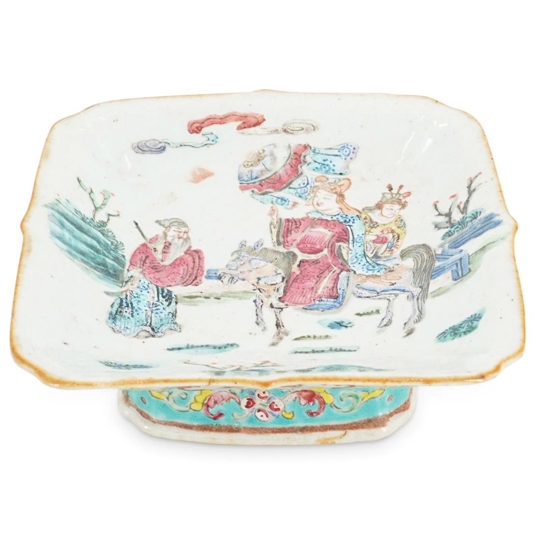 Antique Chinese Famille Rose Porcelain Footed Dish: DESCRIPTION: Antique Chinese famille rose porcelain footed dish featuring a square bowl atop a tapering foot, a polychrome enameled depiction in the well of figures riding horses, and flower as well a
