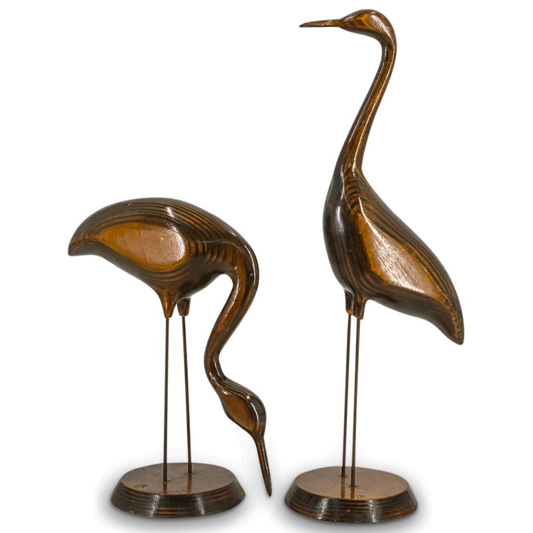 Pair of Vintage Signed Carved Wood Crane Sculptures: DESCRIPTION: Pair of vintage minimalist carved wood sculptures of two cranes in varying poses composed of layered wood slices and mounted on metal legs in a tapering round base. Incised atop the base 