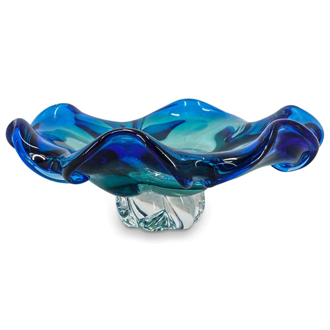Murano Glass Footed Ashtray: DESCRIPTION: Murano glass ashtray featuring a gradient blue to clear tone conspiring from the folded flower petal rim, atop a clear ribbed foot. CIRCA: 20th Century ORIGIN: Italy DIMENSIONS: H: 3.62" 