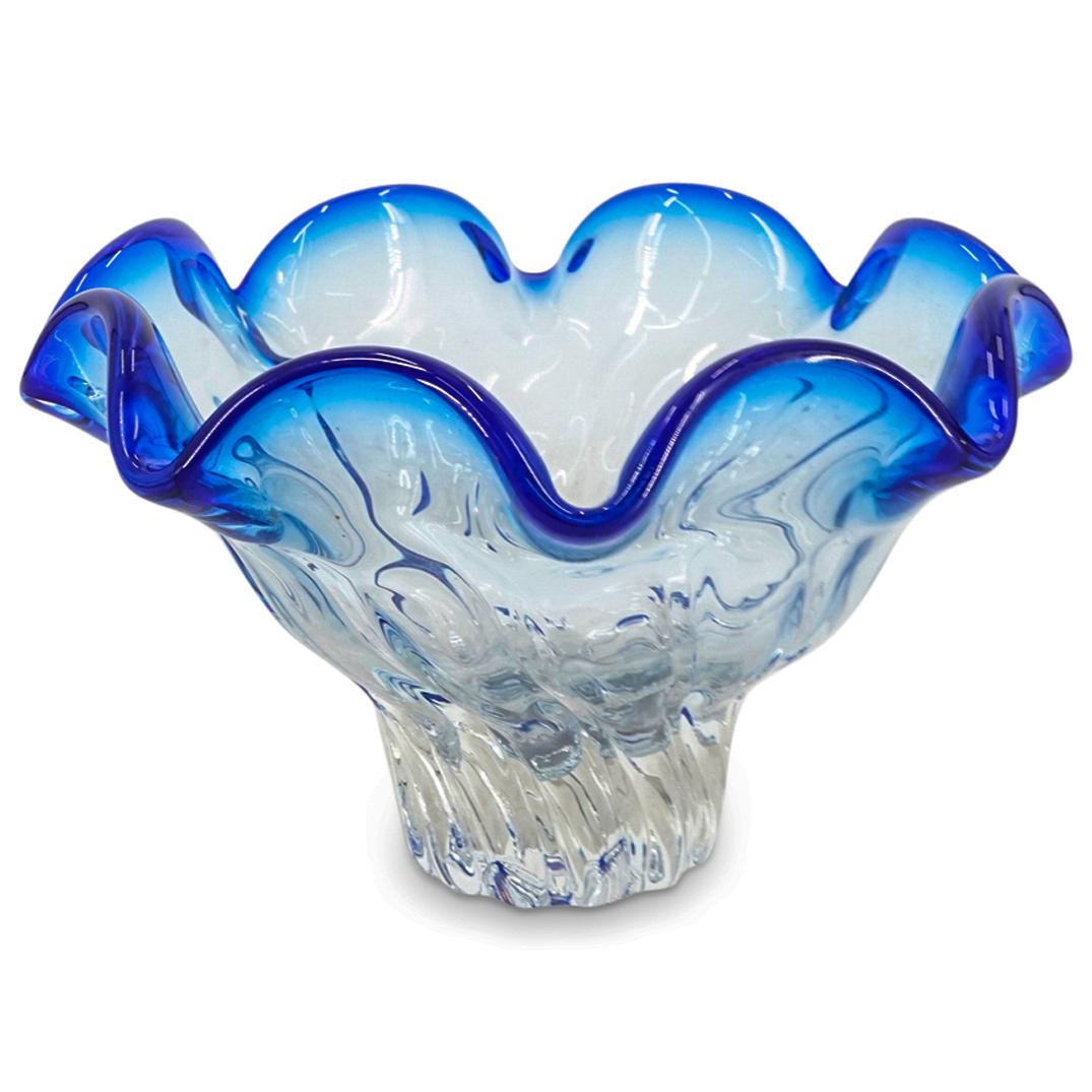 Murano Glass Footed Bowl: DESCRIPTION: Murano glass footed bowl comprising of a blue handkerchief rim transitioning to a clear body, atop a ribbed spiraling foot. CIRCA: 20th Century ORIGIN: Italy DIMENSIONS: H: 5.75" D: 9.62"
