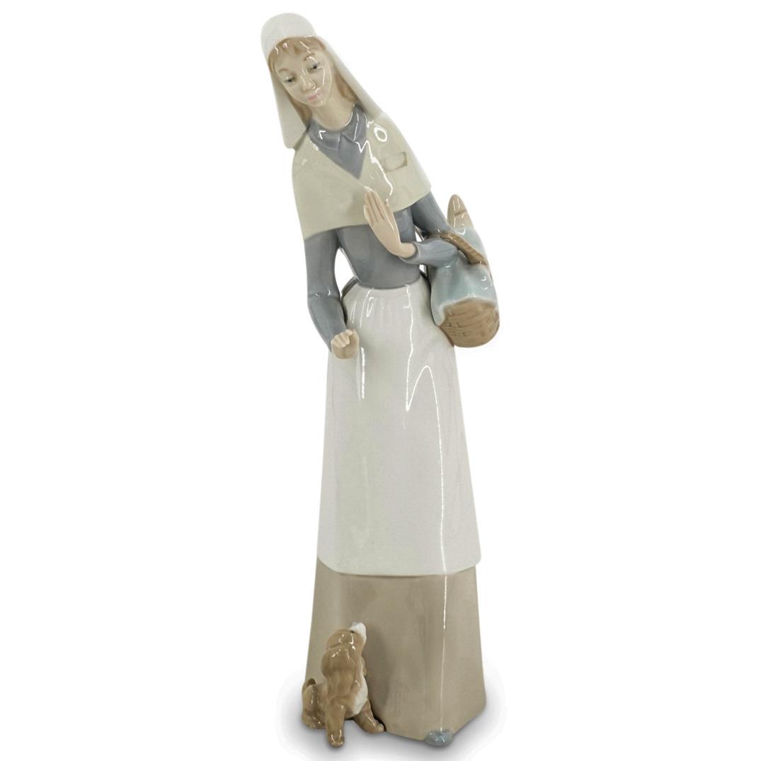 Lladro Porcelain "Shepherdess With Dog" Figurine: DESCRIPTION: A Lladro glazed porcelain figurine titled: "Shepherdess With Dog", model #1034. By Designer Julio Fernandez. Designed in 1970. Retired in 1990. Marked with the Lladro blue hallmark on the