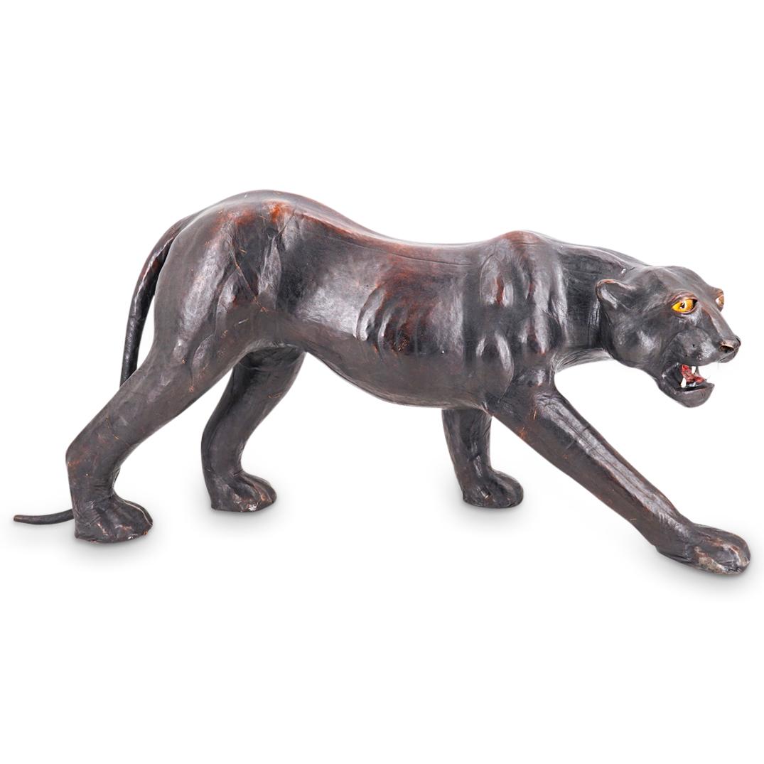 Large Mid Century Leather Panther: DESCRIPTION: Realistic panther figure coated in leather, fashioned with glass eyes, and posed in a sharp toothed snarl. CIRCA: Mid-20th Century ORIGIN: Continental DIMENSIONS: H: 18.25" W: 12.5" L: 37