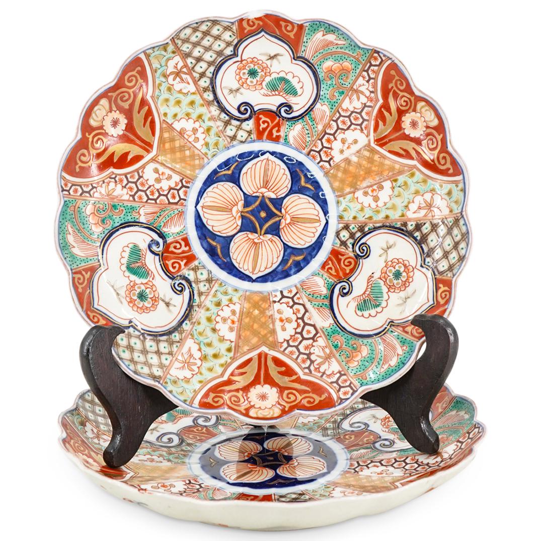 Pair of Antique Japanese Imari Porcelain Plates: DESCRIPTION: Pair of antique Japanese Imari porcelain plates featuring handkerchief rims rays of varying geometric patterns and floral designs. CIRCA: Early 20th Century ORIGIN: Japan DIMENSIONS: H: 1