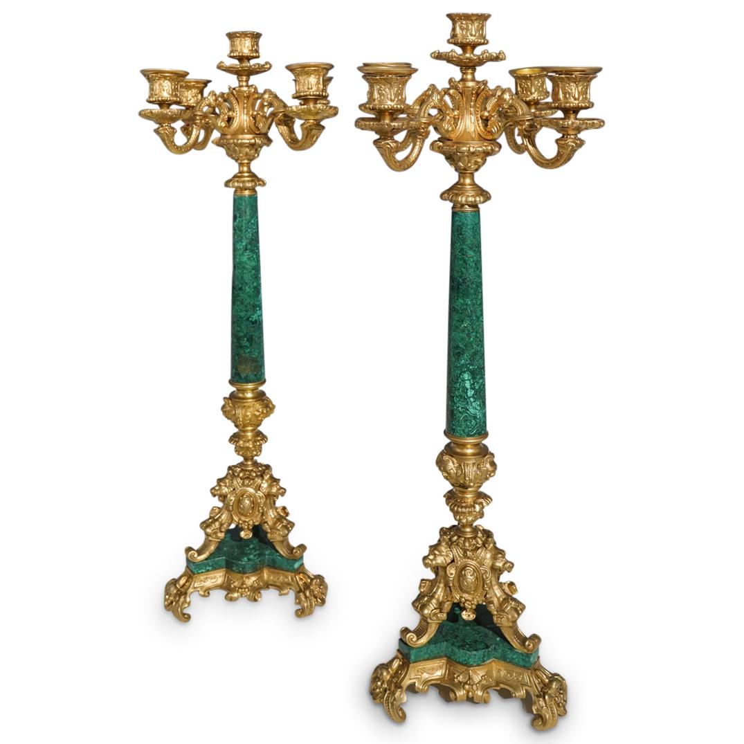 Pair of Empire Style Gilt Bronze and Malachite Candelabras: DESCRIPTION: A Pair of Empire style candelabras comprised of a bronze top candelabrum, and base decorated with ornate designs with animalistic visages. The center column and base inserted with malachi