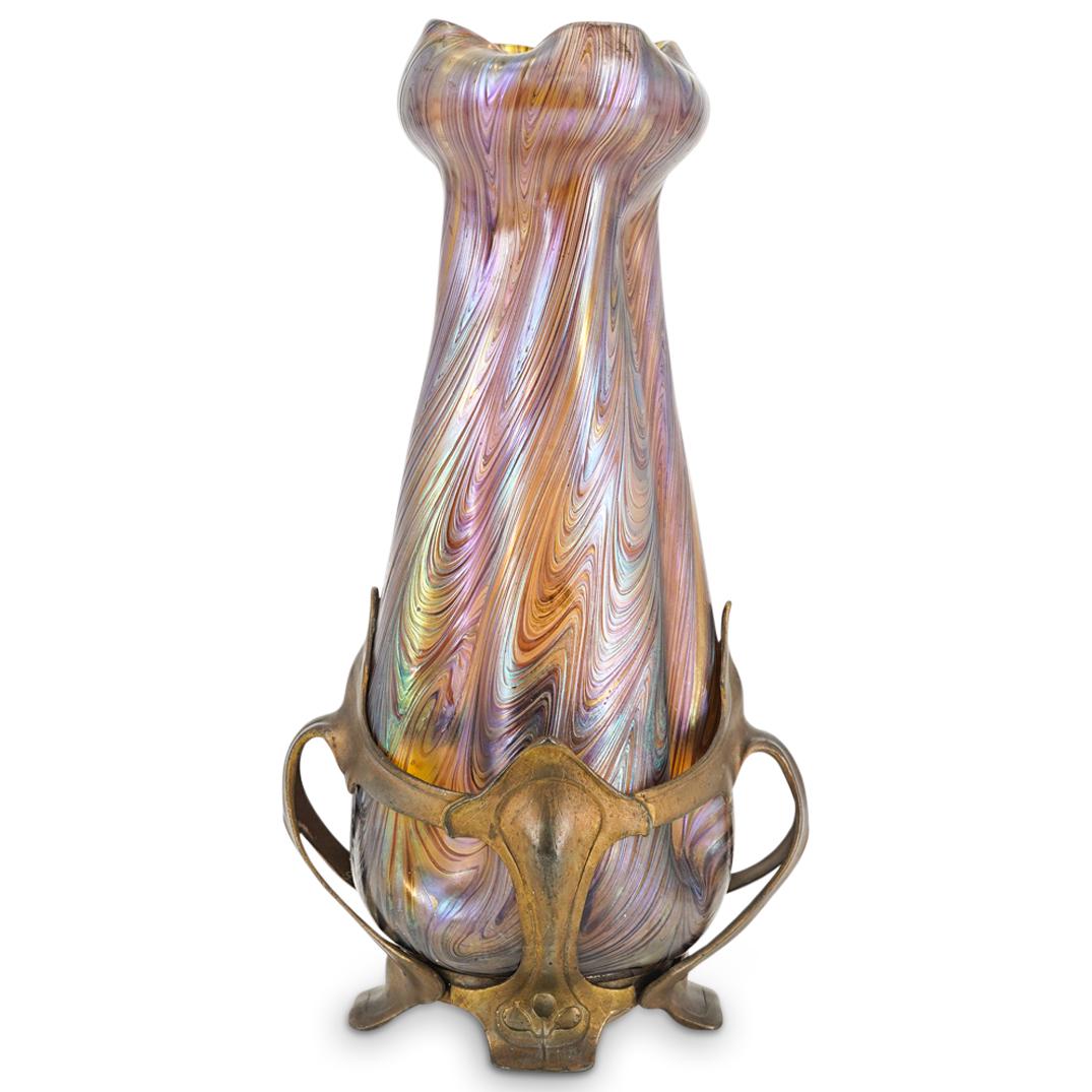 Art Nouveau Loetz Pewter & Iridescent Glass Vase: DESCRIPTION: Art Nouveau Loetz and Friedrich van Hauten glass vase presenting an ornate iridescent purple and blue tone throughout, a ribbed indented form surmounted by a curled bud form rim completed
