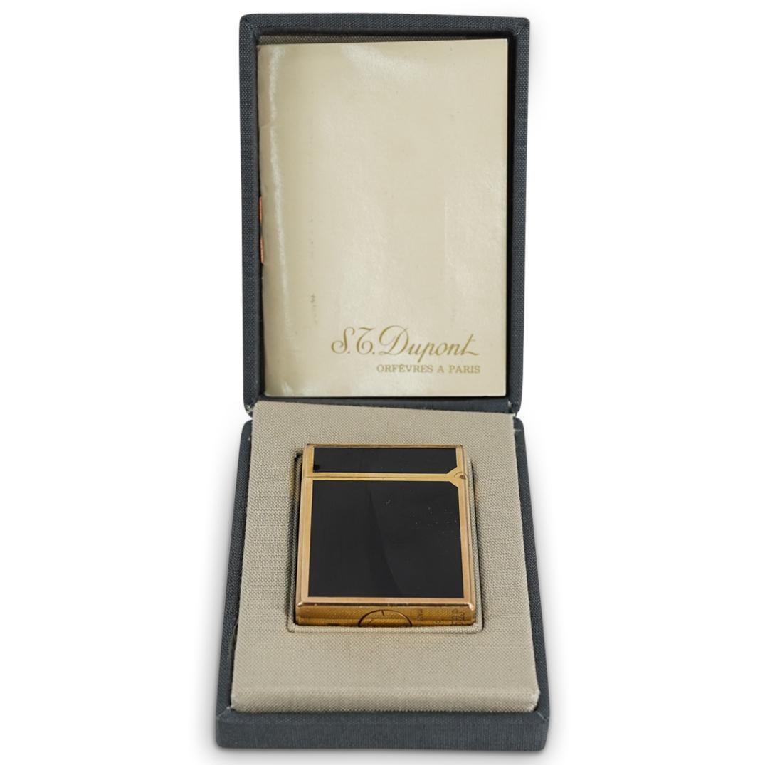S.T. Dupont Gold Plated Lighter: DESCRIPTION: S.T. Dupont lighter composed of an overall black enamel and gold plated foundation. Marked on bottom "S.T. Dupont, Made In France, Paris". and AEF336. Includes original case and instructi