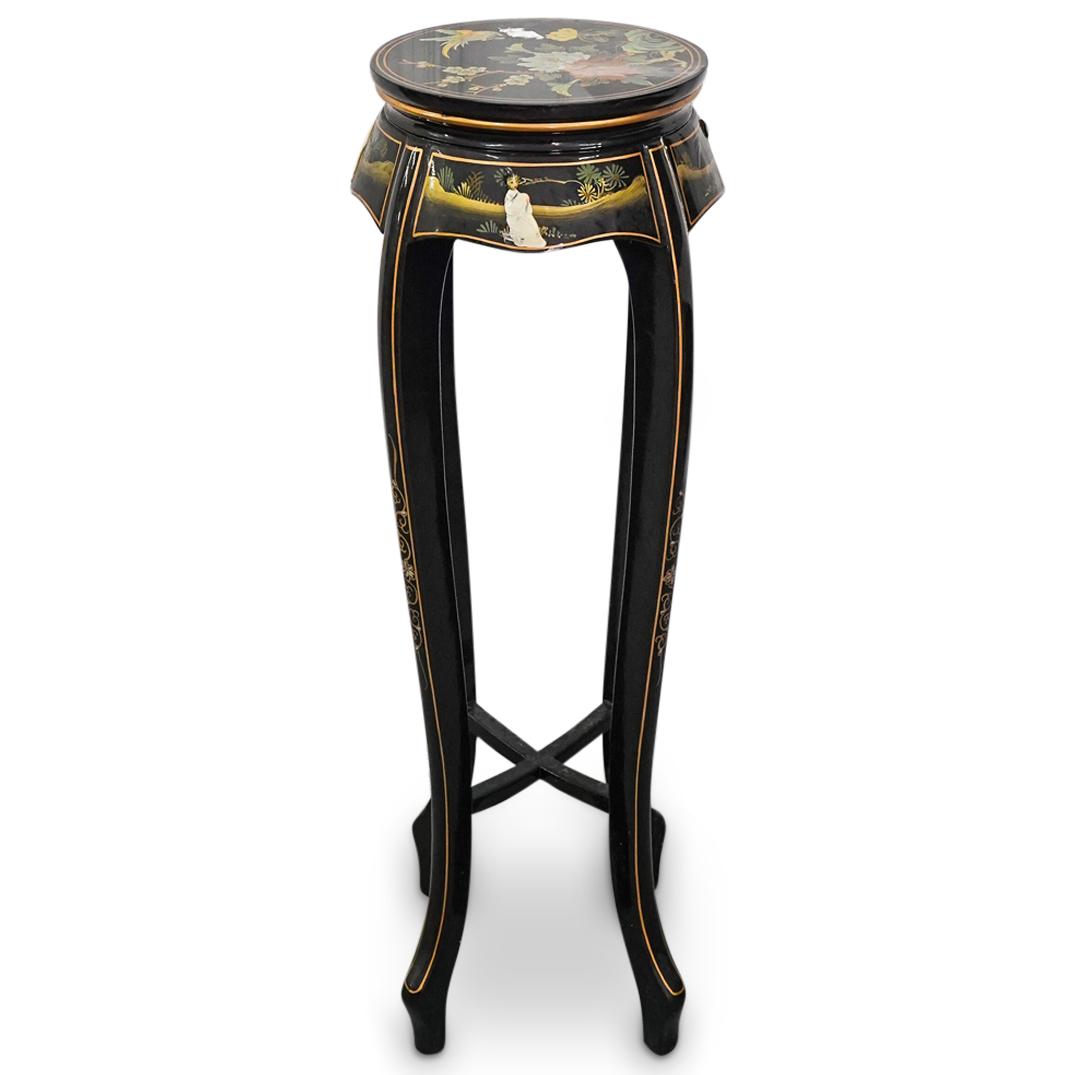 Vintage Chinese Lacquered Wood, Mother Of Pearl Pedestal: DESCRIPTION: Lacquered, carved wood four footed pedestal decorated on its skirt with seated mother-of-pearl female figural applications against foliage laden backgrounds. Finished on platform with flo