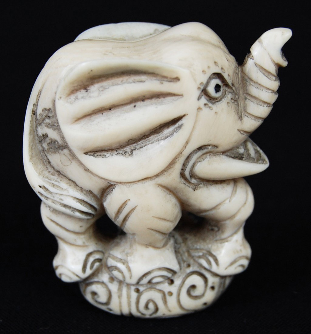 Antique Hand Carved Ivory Elephant Netsuke: DESCRIPTION: Carved elephant netsuke with raised trunk CIRCA: Early 1900's MADE IN: China DIMENSIONS: H: 2'' RESERVE: None