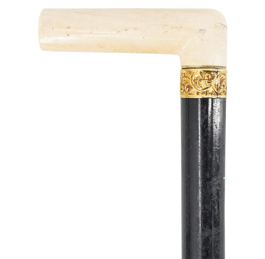 Antique Ebonized Bone And 14K Gold Handled Wooden Cane: DESCRIPTION: Antique ebonized can featuring a carved bone handle accented with a 14K gold ring embellished with raised foliage designs and a medallion monogrammed "D.N. Kownover" suggesting the initia