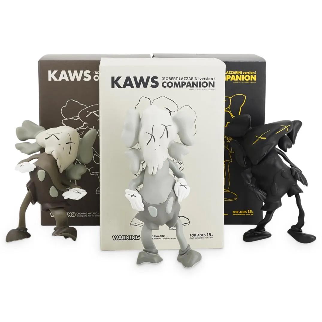 (3Pc) Kaws Companion X Robert Lazzarini Vinyl Set: DESCRIPTION: (3Pc) Kaws Companion X Robert Lazzarini editions (Brown) (Grey) (Black) Vinyl figures. Stamped to underside of feet: (KAWS LAZZARINI/ 2010 / MEDICOM TOY / CHINA) Original box and packagin
