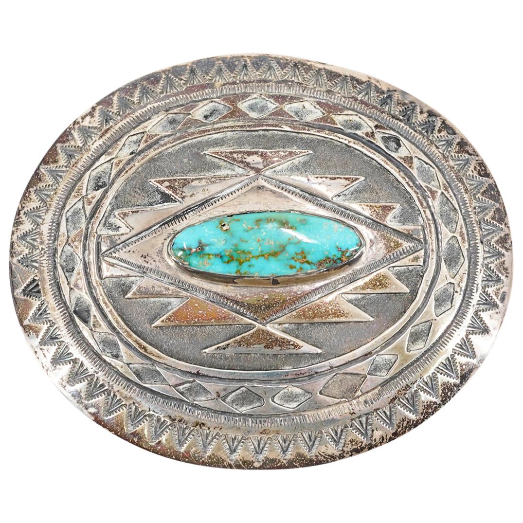 NNB Sterling Silver Turquoise Inset Navajo Pattern Belt Buckle: DESCRIPTION: Sterling silver belt buckle signed "N N B" featuring an oblong turquoise inset bordered by etched geometric patterns typical of Navajo art. Marked on verso "N N B STERLING". Includes blac
