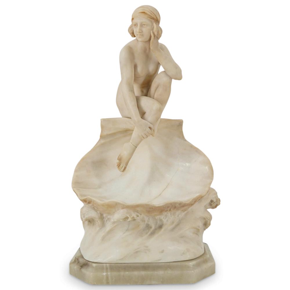 Art Nouveau Italian Alabaster Nude Woman On Shell Lamp: DESCRIPTION: Art Nouveau alabaster table lamp crafted as a woman seated on a seashell atop a rolling wave. Lamp is mounted on a marbled alabaster base and is fully functional. Marked on verso "Made in