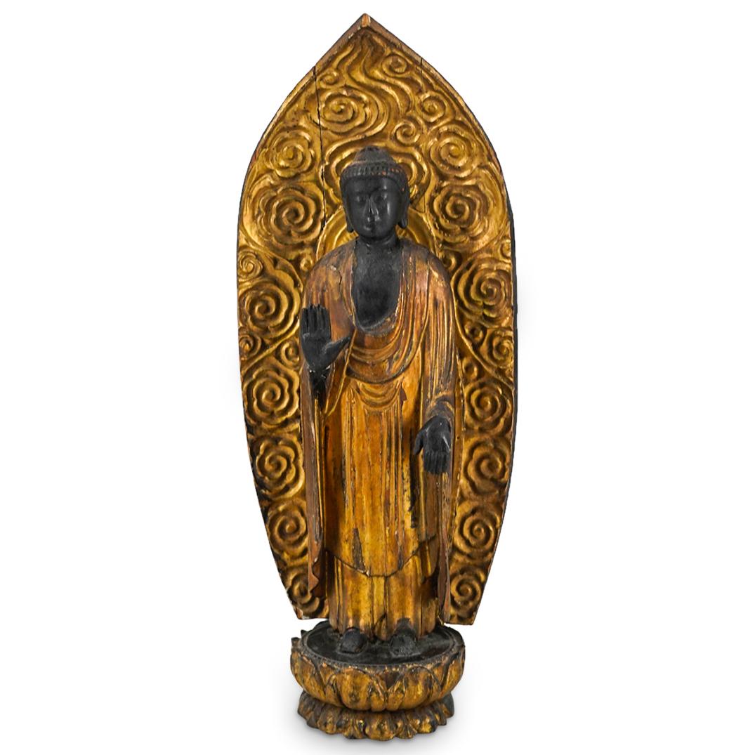 Ex-Christies Ebonized & Gilt Lacquered Wood Buddha: DESCRIPTION: An antique ebonized and gilt lacquered wood carved figure of Buddha with upright posed deity in drapped robe, raised atop a double lotus throne with flaming aureole. Christies auction lab
