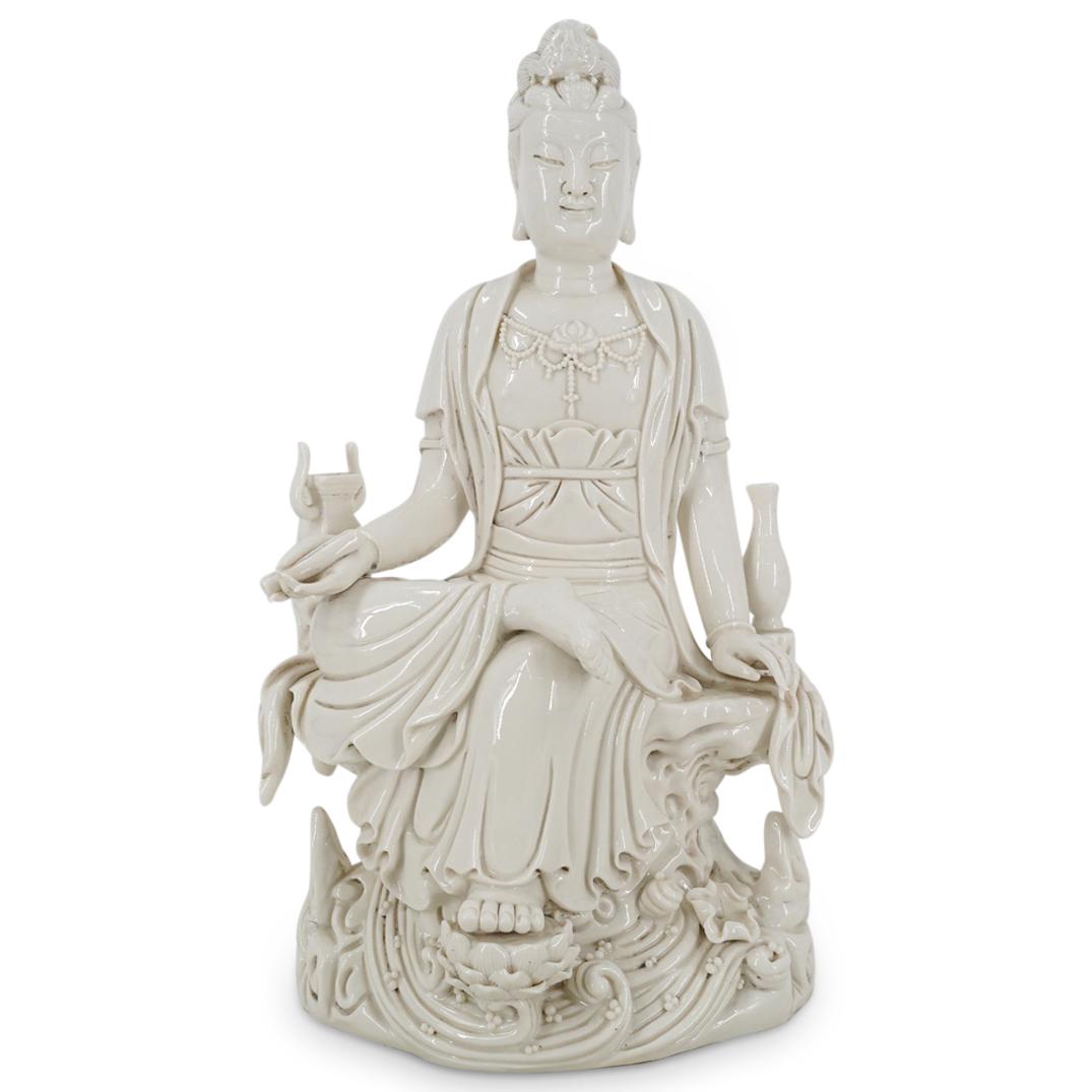 Chinese Blanc De Chine Seated Guan Yin Sculpture: DESCRIPTION: A Chinese Blanc De Chine porcelain sculpture depicts a seated guan yin, robed atop a lotus pedestal and surrounded by scholarly objects. CIRCA: 20th Century ORIGIN: China DIMENSIONS: H: 1