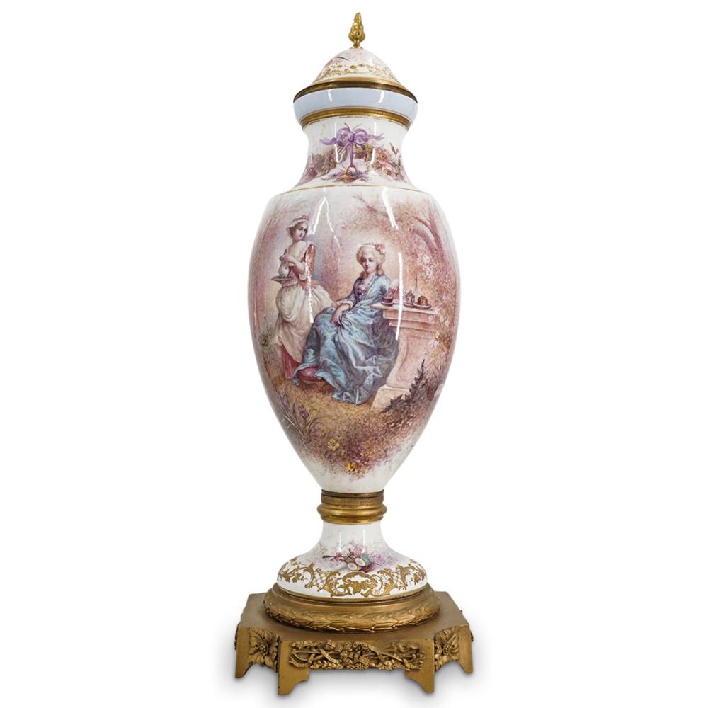 Antique French Shouldered Porcelain Vase: DESCRIPTION: Antique porcelain vase featuring a shouldered design mounted on a bronze base and decorated with an image of a noblewoman having tea in a garden signed M. Demonceaux. Piece is embellished