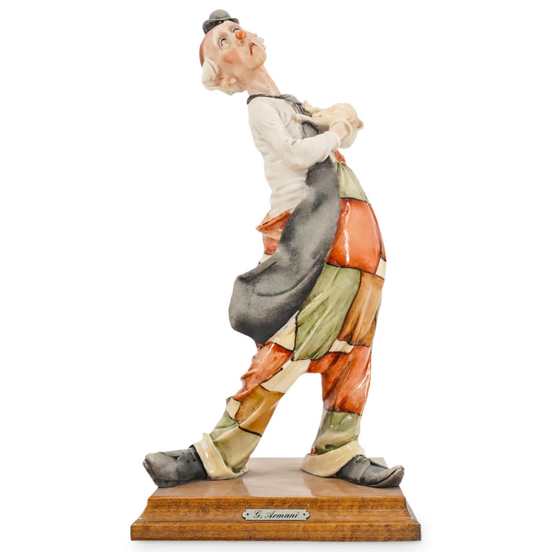 Giuseppe Armani Porcelain Clown Sculpture: DESCRIPTION: A Giuseppe Armani sculpture depicts a clown in overalls decorated with polychrome accents, fitted atop a wooden base. Marked "GA" with Italian porcelain mark. CIRCA: 20th Century ORIGIN: