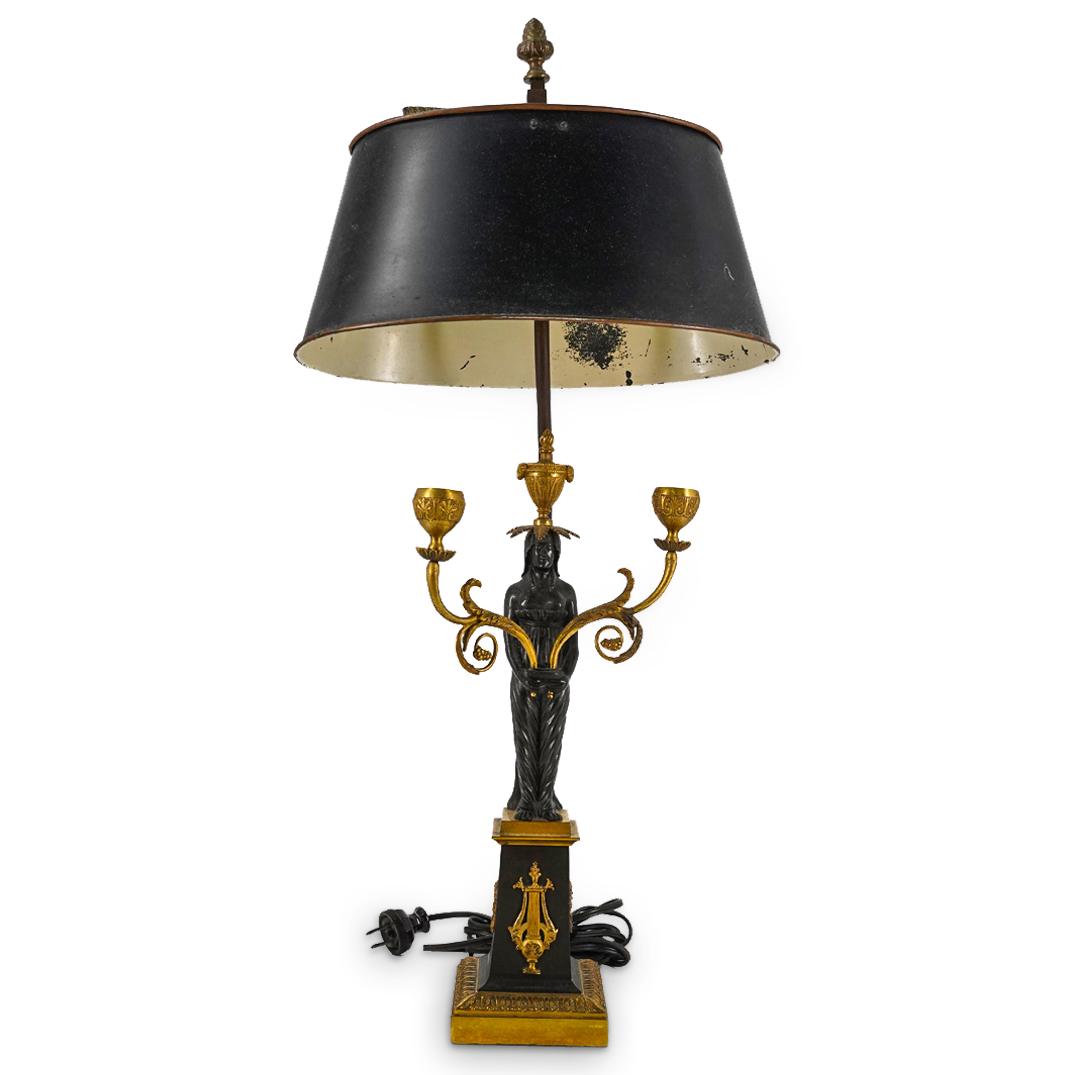 Antique French Neoclassical Bronze And Metal Table Lamp: DESCRIPTION: Double socket, electric table lamp composed of a bronze base fashioned as a plinth adorned on the sides with lyres and wreaths and supporting a semi-nude woman carrying two foliage form c