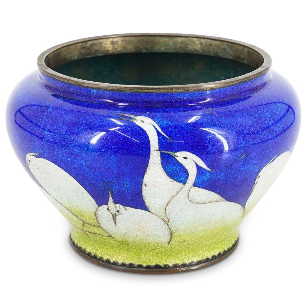 Meiji Japanese Enamel Crane Vase: DESCRIPTION: A Japanese silver vase with blue, white, and green colored enamel depicting a group of cranes. CIRCA: 20th Cent. ORIGIN: Japan DIMENSIONS: H: 4.75" x D: 7" Have a similar item to sell? Re