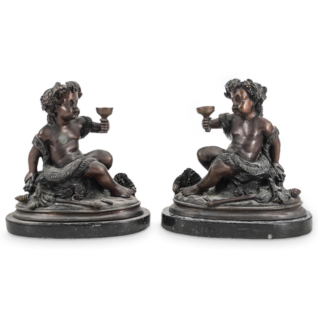 Pair Of After Ercole Ferrata Bronze Dionysian Puttos: DESCRIPTION: Two mirrored, patinated bronze sculptures, each depicting a Putti dressed as Dionysus for a bacchanalia in a goatskin and grapevine crown bearing a wine chalice and seated next to a Thyrs