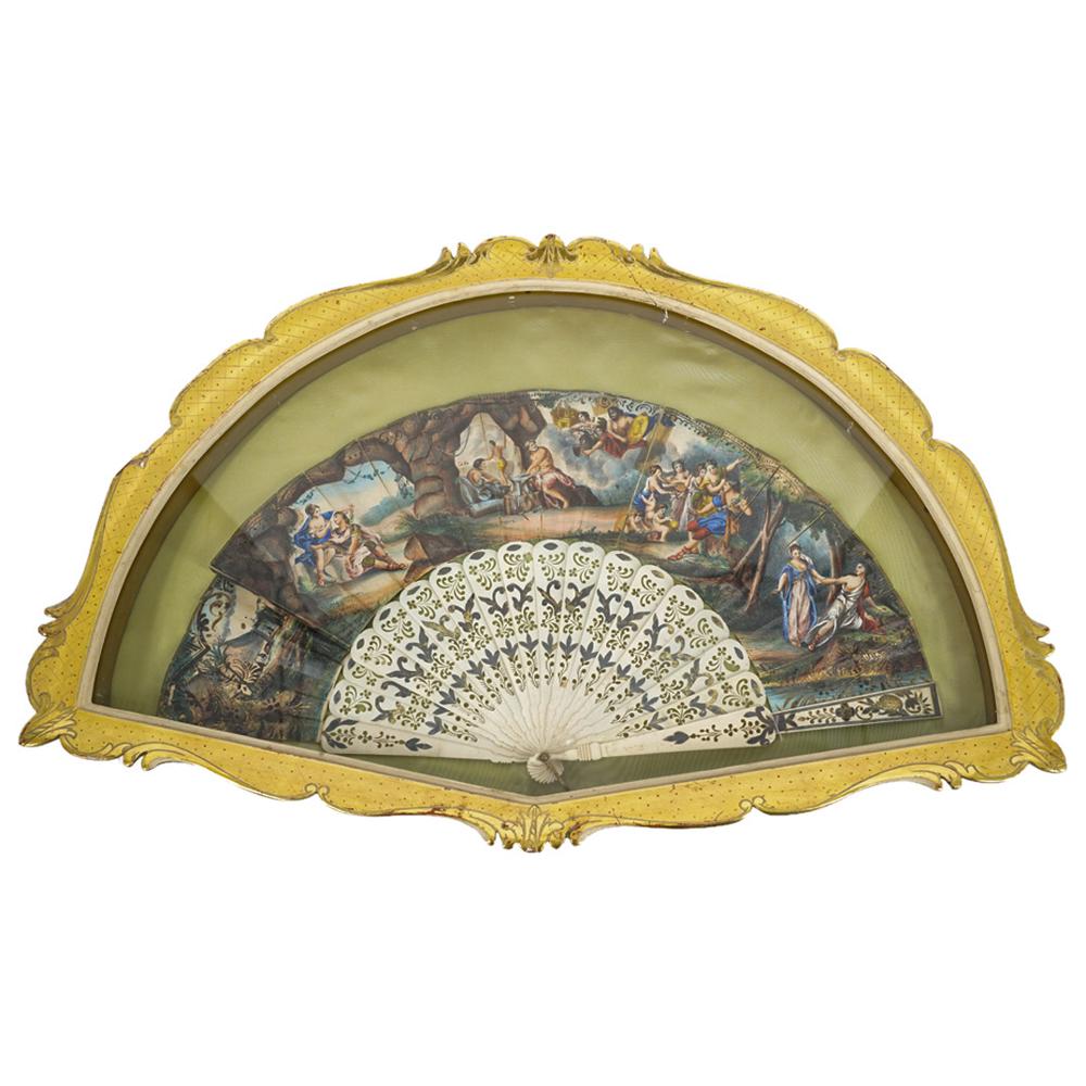 Antique French Framed Neo Classical Folding Carved Bone Hand Fan: DESCRIPTION: Carved bone folding fan decorated on its canvas with neo-classical scenes and carved floral and foliage piercings and designs in its slats. Mounted in a gilt foliage and lattice patterned