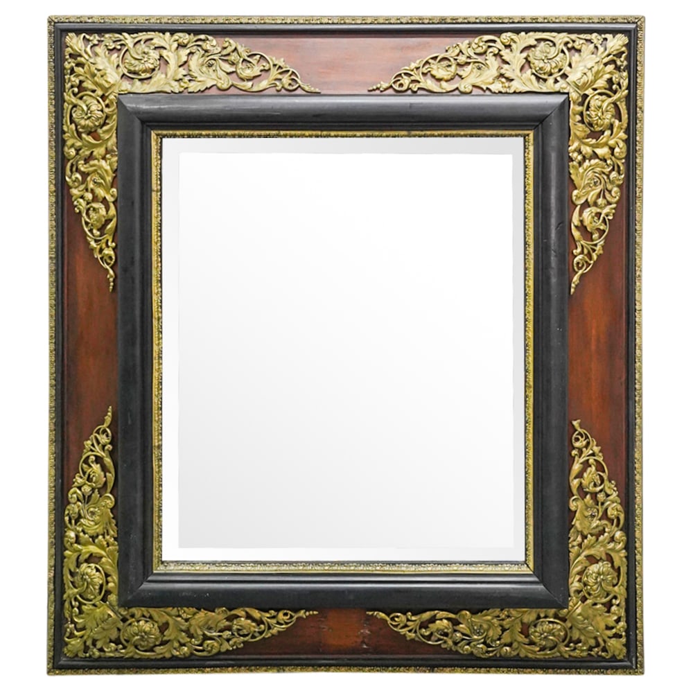 Antique French Carved Wood And Brass Overlaid Mirror: DESCRIPTION: Antique carved wood mirror featuring brass foliage bordering the mirror proper and outer edge and gilt brass floral and foliage applications at each corner. CIRCA: 19th Century ORIGIN: Fr