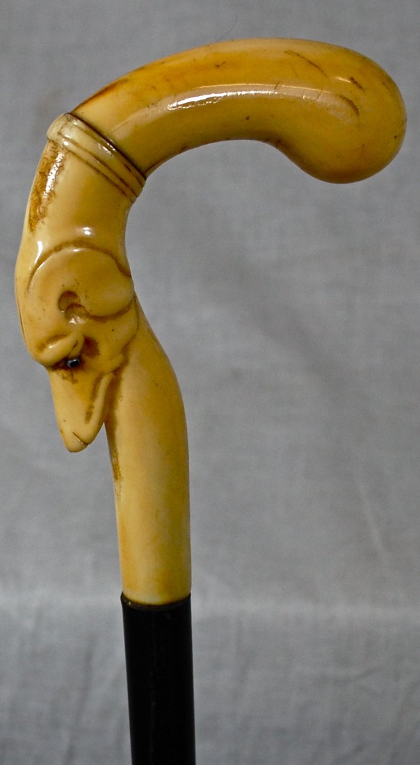 Hand Carved Ivory cane with dog carved into handle: DESCRIPTION: Hand Carved Ivory cane with dog carved into handle. The shaft is a dark wood resembling ebony. Curved ivory handle with dog carved on the curve. CIRCA: 1890s MADE IN: France DIMENSIONS: