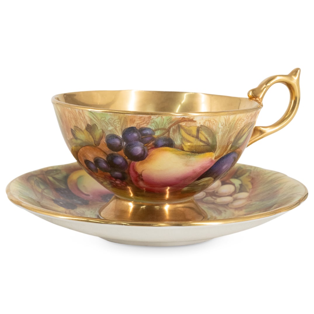 Aynsley English Bone China Tea Cup W/ Saucer: DESCRIPTION: Antique bone china teacup and saucer, each coated in a gilt glaze and decorated with transferred fruit and foliage motifs. Hallmarked on underside. CIRCA: 20th Century ORIGIN: England DIM
