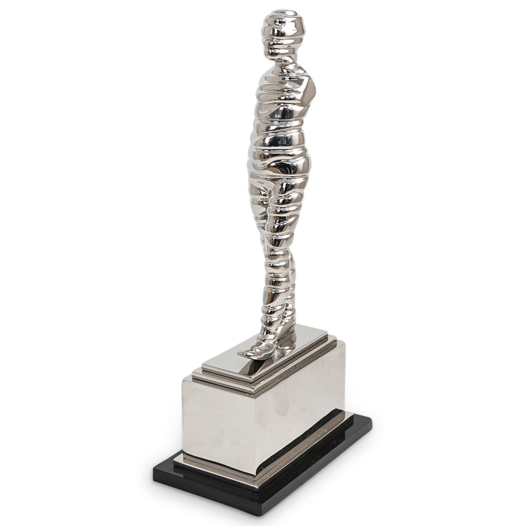 Ernest Trova (American, 1927-2009) "Wrapman" Sculpture: DESCRIPTION: An Ernest Trova sculpture titled "Wrapman" comprised of stainless steel atop an acrylic base. Signed and Editioned. Comes with artist book. CIRCA: 20th Century ORIGIN: USA DIMENSIONS: H: