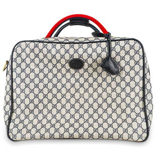 Vintage Gucci Overnighter Travel Luggage Bag: DESCRIPTION: Vintage Gucci printed monogram canvas suitcase overnighter luggage bag with blue leather accents and gold tone hardware. With Gi CIRCA: 20th Century DIMENSIONS: H: 7" W: 18" L: 13" CONDIT