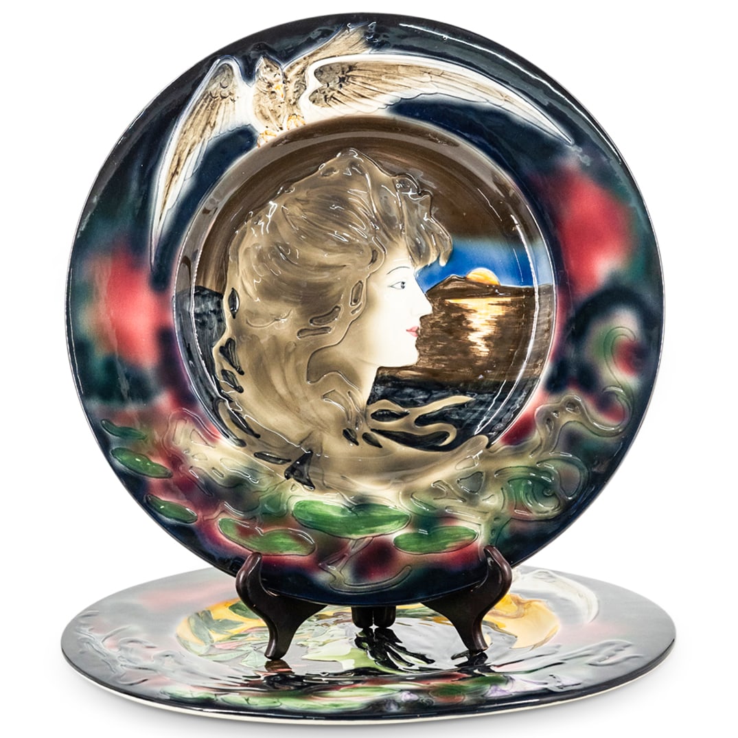 Pair CICO Art Nouveau Style Porcelain Chargers: DESCRIPTION: Pair of Art Nouveau-style porcelain chargers by CICO, each depicting in relief a woman's head in profile with an eagle above. One charger features water, a mountain and the moon in the ba