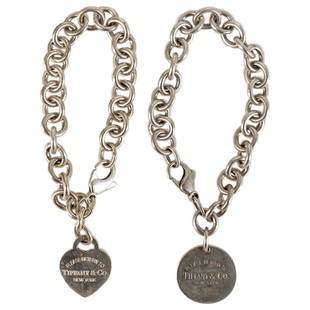 (2 Pc) Tiffany & Co Sterling Silver Bracelets: DESCRIPTION: Two Tiffany & Co. sterling silver bracelets, one featuring circular pendant and the other featuring heart-shaped pendant. Each marked with "925" on pendant and chain clasp. Total weight: