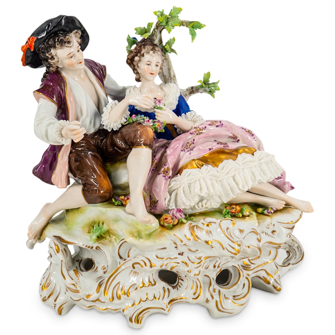 Antique Aelteste Volkstedter Porcelain Figural Group: DESCRIPTION: Antique Aelteste Volkstedter polychrome porcelain figural sculpture depicting two courting lovers and featuring floral and foliage motifs, gilt accents and openwork "lace". Hallmarked on 