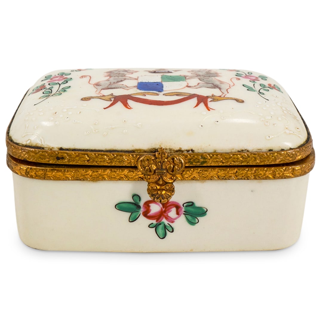 Antique Armorial Porcelain Trinket Box: DESCRIPTION: Antique porcelain trinket box featuring hand painted floral and foliage motifs and coat of arms with lions. Completed with enamel accents. Partially worn mark on underside. CIRCA: Mid 19t