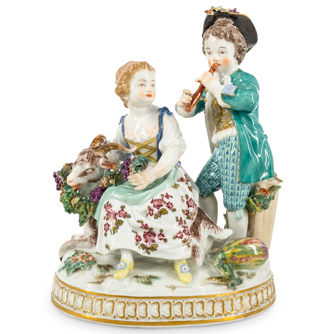 Antique Meissen Porcelain Group Figurine: DESCRIPTION: Antique Meissen Porcelain group figurine depicting a pastoral scene with a young girl seated next to a goat that eats grapes on a vine, and a boy standing next to the girl by her left sid