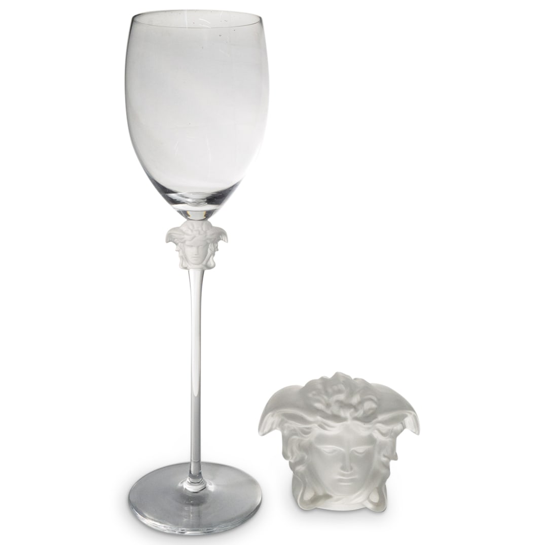 (2 Pc) Rosenthal Versace Medusa Paperweight & Wine Glass: DESCRIPTION: Two Rosenthal Versace crystal pieces - one a paperweight in the form of the head of Medusa, one a wine glass featuring the Medusa head beneath the bowl. Each piece marked "Rosenthal Versa