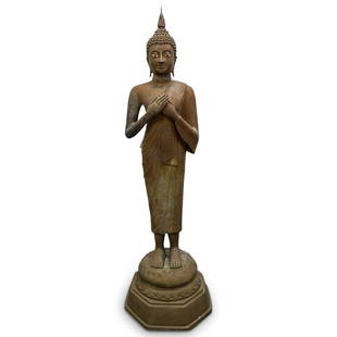 Antique Southeast Asian Bronze Buddha: DESCRIPTION: Antique Buddhist bronze sculpture depicting Siddhartha Gautama standing on a lotus throne atop an octagonal base with his hands over his chest. Eyes are enameled white and black, and