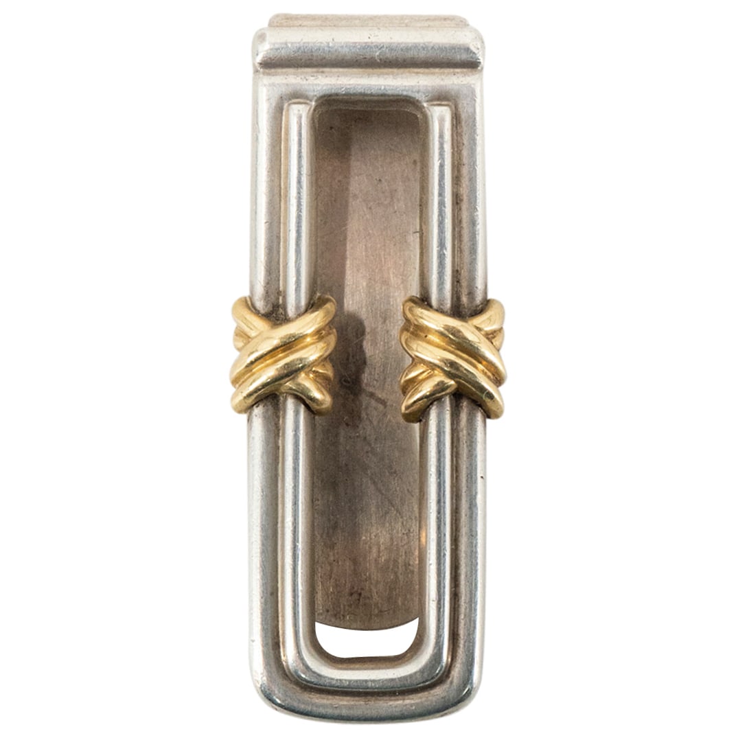 Tiffany & Co Sterling Silver Money Clip: DESCRIPTION: Sterling silver money clip by Tiffany & Co featuring gilt accented knots on front. Hallmarked on underside CIRCA: 1995 ORIGIN: USA DIMENSIONS: H: 0.5" W: 0.75" L: 2" CONDITION: Minor wear