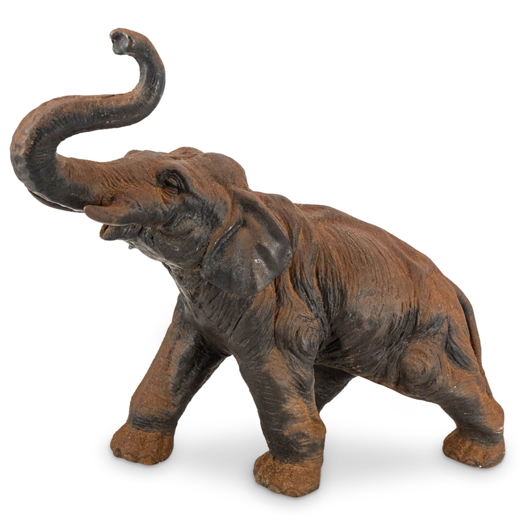 Vintage Cast Iron Elephant Sculpture: DESCRIPTION: Vintage cast iron elephant sculpture with a bronze patina finish. The elephant is designed with raised trunk and standing walking naturalistic pose. CIRCA: 20th Century ORIGIN: Unknown DI