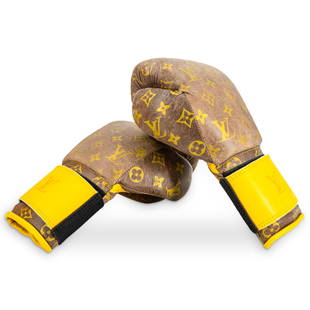 Pair Of Louis Vuitton Style Boxing Gloves: DESCRIPTION: Two matching Louis Vuitton style leather boxing gloves featuring yellow straps and a gilt Louis Vuitton logo and floral pattern. CIRCA: 20th Century ORIGIN: Continental DIMENSIONS: H: 5"