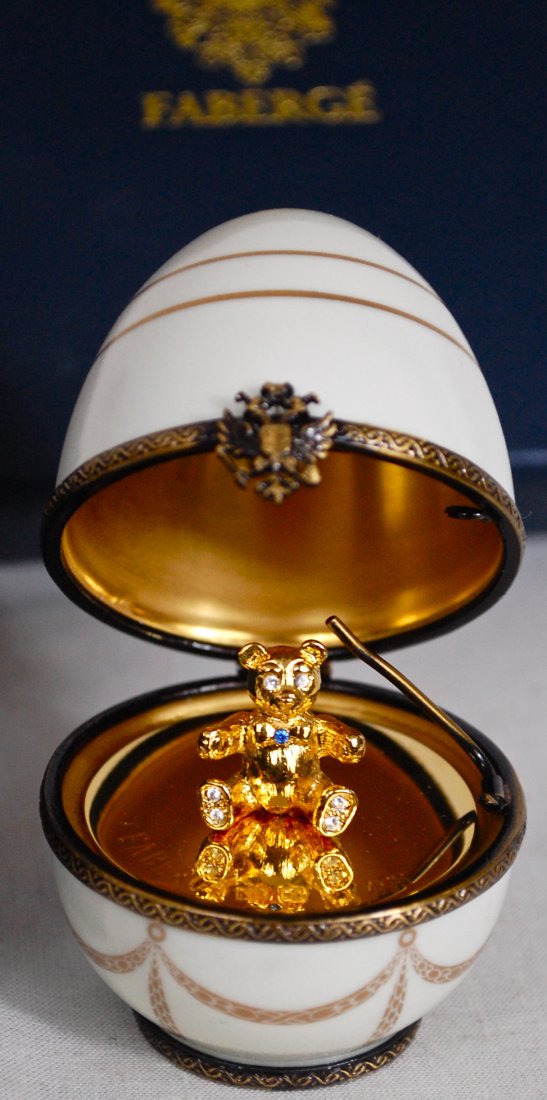 Vintage Faberge porcelain white egg: DESCRIPTION: Vintage Faberge porcelain white egg with a bronze trim and a small Dore teddy bear inside. Hallmarked on the bottom " Hand Painted Limoges France Faberge" in French. Comes with authentica