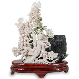 Antique Chinese Jade Carved Guanyin Sculpture: DESCRIPTION: Antique Chinese jade carved sculpture depicting a Guanyin with intricate cherry blossom floral open-work design, completed with dark colored shelter in the background, displayed on wood