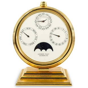 Audemars Piguet Gilt Brass Perpetual Calendar 2100 Desk Clock: DESCRIPTION: Audemars Piguet gilt brass perpetual calendar 2100 desk clock indicating month, day, date, leap year, and moon phase and adjusted by push button at top. "N 0519" at reverse. CIRCA: 1989 O