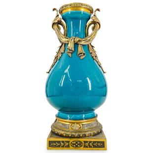 Antique French Porcelain and Bronze Mounted Urn: DESCRIPTION: An antique french bronze urn comprised of a teal ground color, mounted on either side with ornate acanthus leaf handles with draping cloth along the neck. Finished with ornate bronze rim