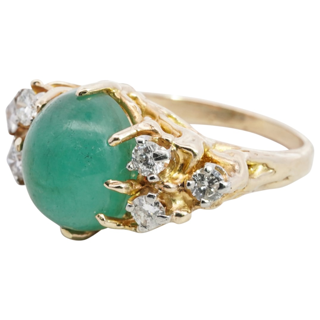 14k Gold Emerald and Diamond Ring: DESCRIPTION: 14k yellow gold ring featuring a central 2.5 carat emerald cabochon flanked on either side with (6) .10ct diamonds. Total weight: 7.1 grams (4.6 dwt) CIRCA: 20th Cent. ORIGIN: USA DIMENSI