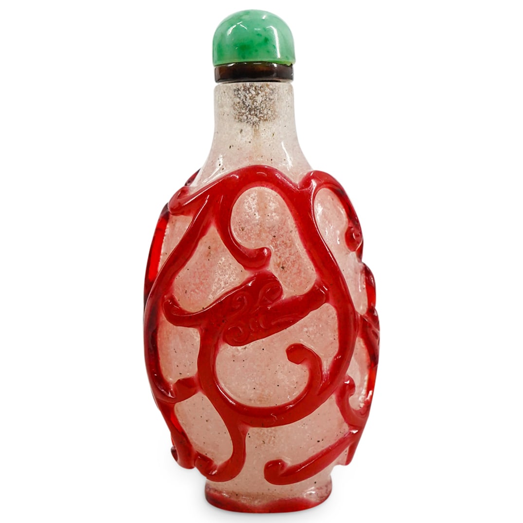 Antique Chinese Peking Glass Chilong Snuff Bottle: DESCRIPTION: An antique Chinese peking glass snuff bottle featuring an overlay of red on snow flake glass, a relief depicting Chi dragon design on both sides, a flattened ovate flask form, and an oval