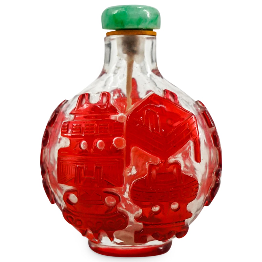 Antique Chinese Peking Glass Snuff Bottle: DESCRIPTION: Antique Chinese Peking Glass Snuff Bottle decorated with red overlay depicting scholarly objects. Completed with a jade stopper attached to a bone scooper. CIRCA: 19th Cent. ORIGIN: China